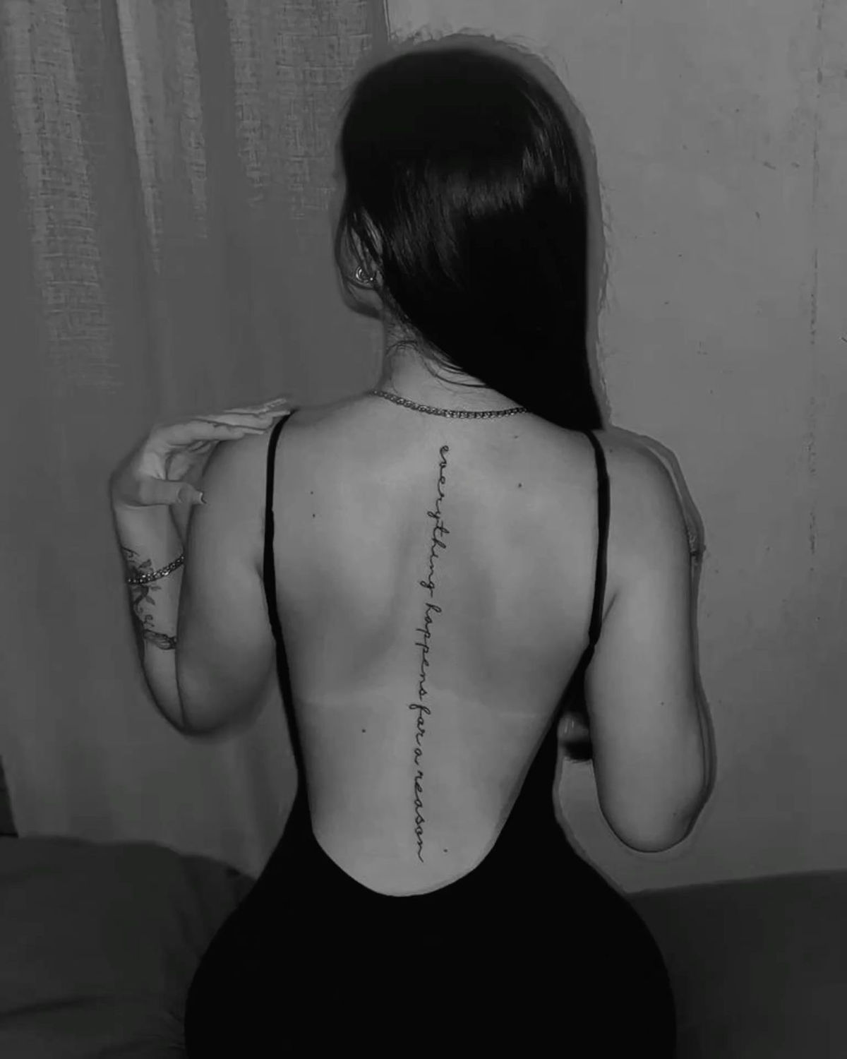 Fine line cursive script tattoo running down the spine, healed cleanly to illustrate proper tattoo aftercare in Lahore's climate