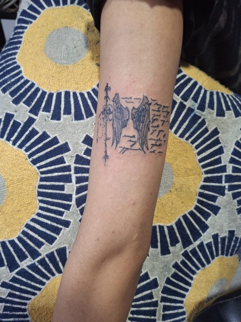 Fine line wings and script tattoo done at Devil Art Studio, Lahore