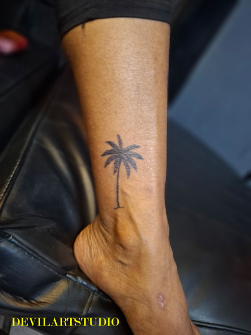 Creative palm tree tattoo design used as a scar cover up solution in Lahore