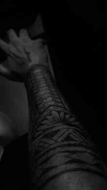 Close up detail of a Polynesian tribal sleeve tattoo with hexagon and floral pattern done at Devil Tattoo Lahore