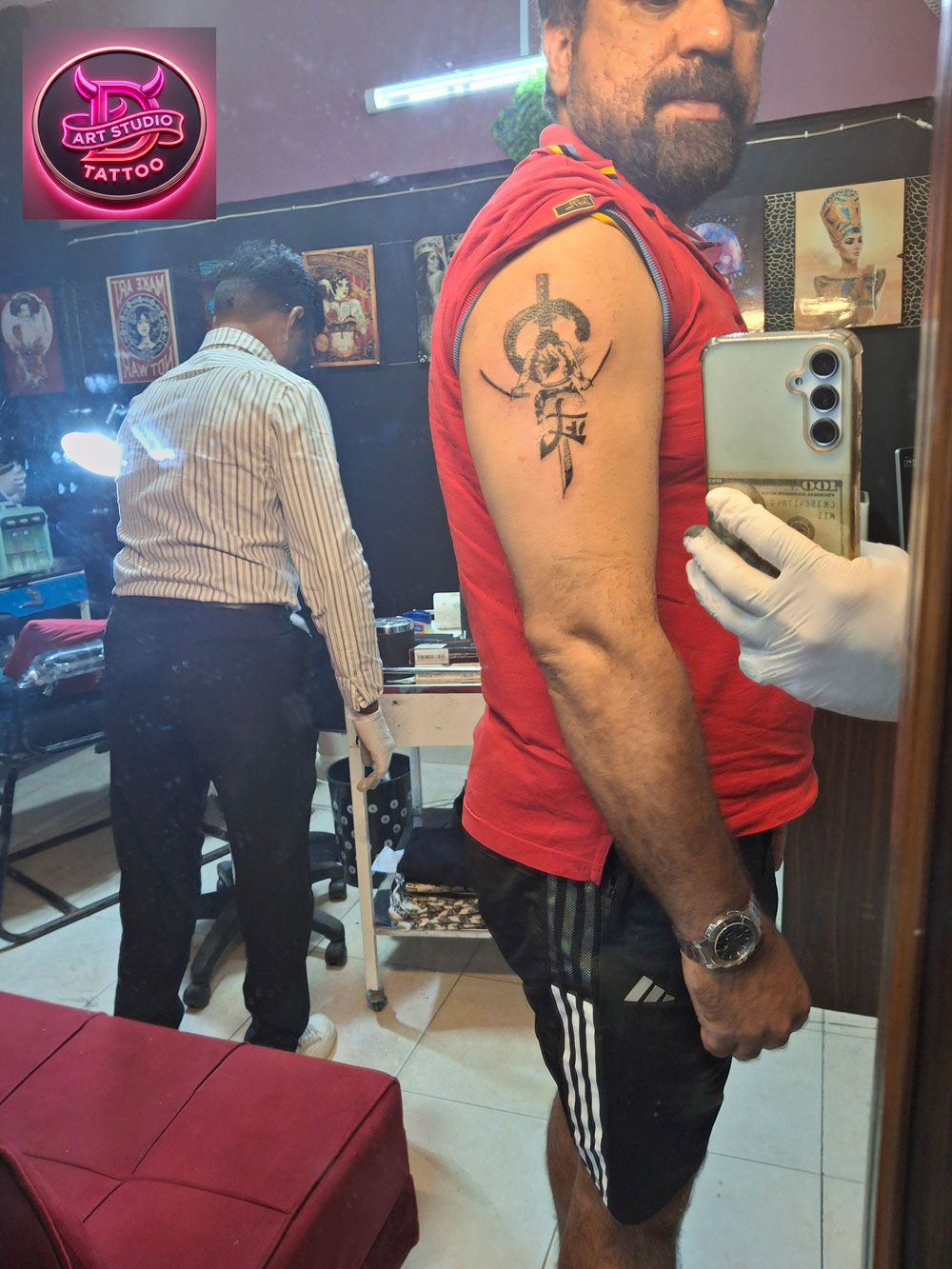 Bold blackwork emblem tattoo on a man's arm by Devil Art Studio Lahore