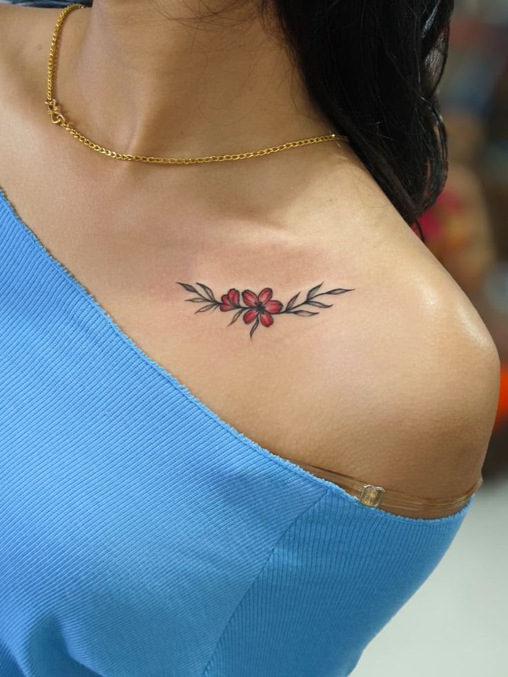 Small red flowers collarbone tattoo by Devil Art Studio Lahore