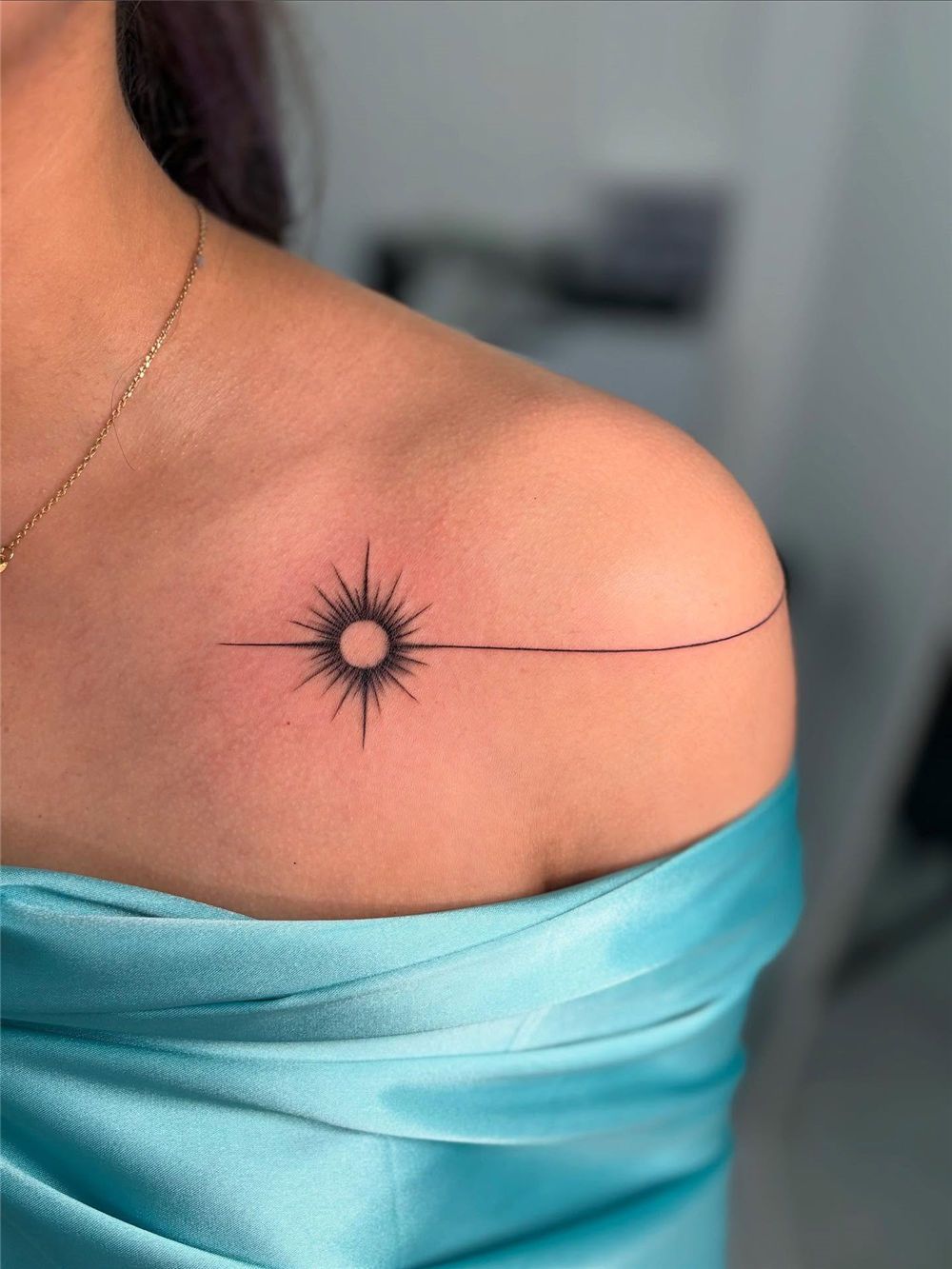 Minimalist sunburst line tattoo on collarbone by Devil Art Studio Lahore